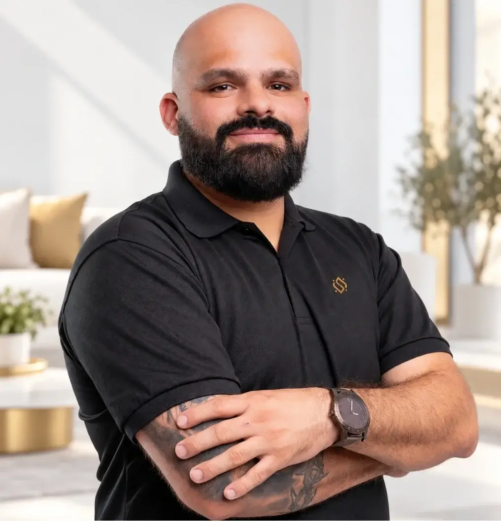 Sydney Neto, founder of Syd's Cleaning Service, wearing a company polo in a bright living room