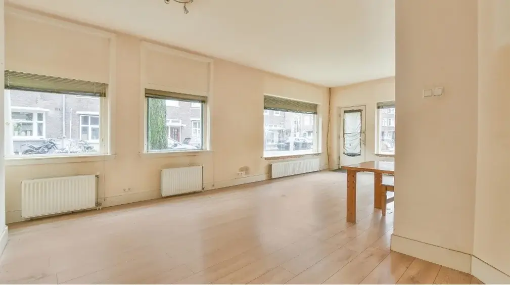 Empty, freshly cleaned living room with wood floors, ready for move-in day