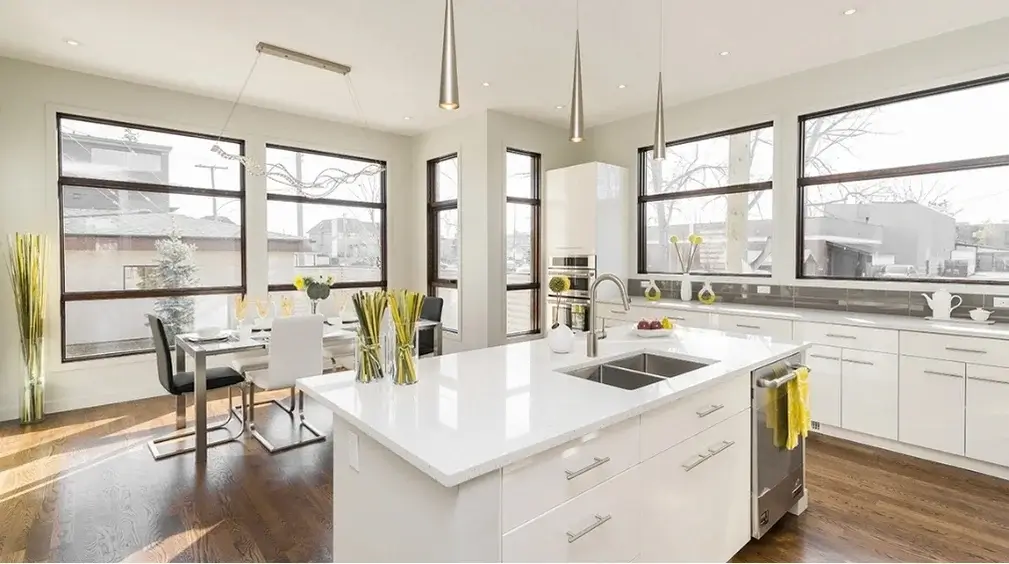 Spotless modern kitchen with a white island and wood floors after a regular house cleaning